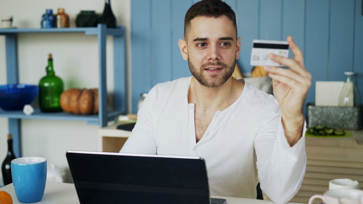 Person handler på nett med betalingskort og laptop