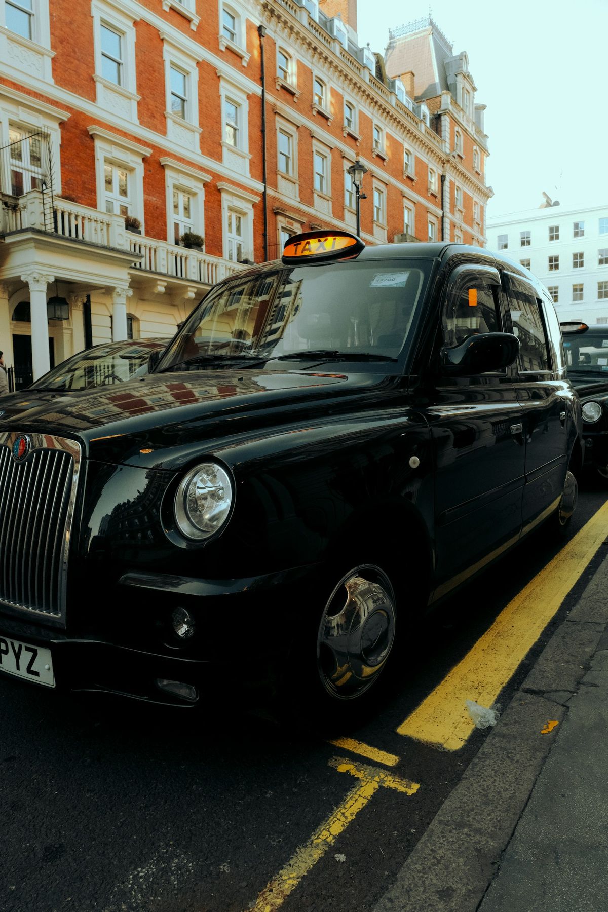 Svart taxi parkert langs gaten i byen