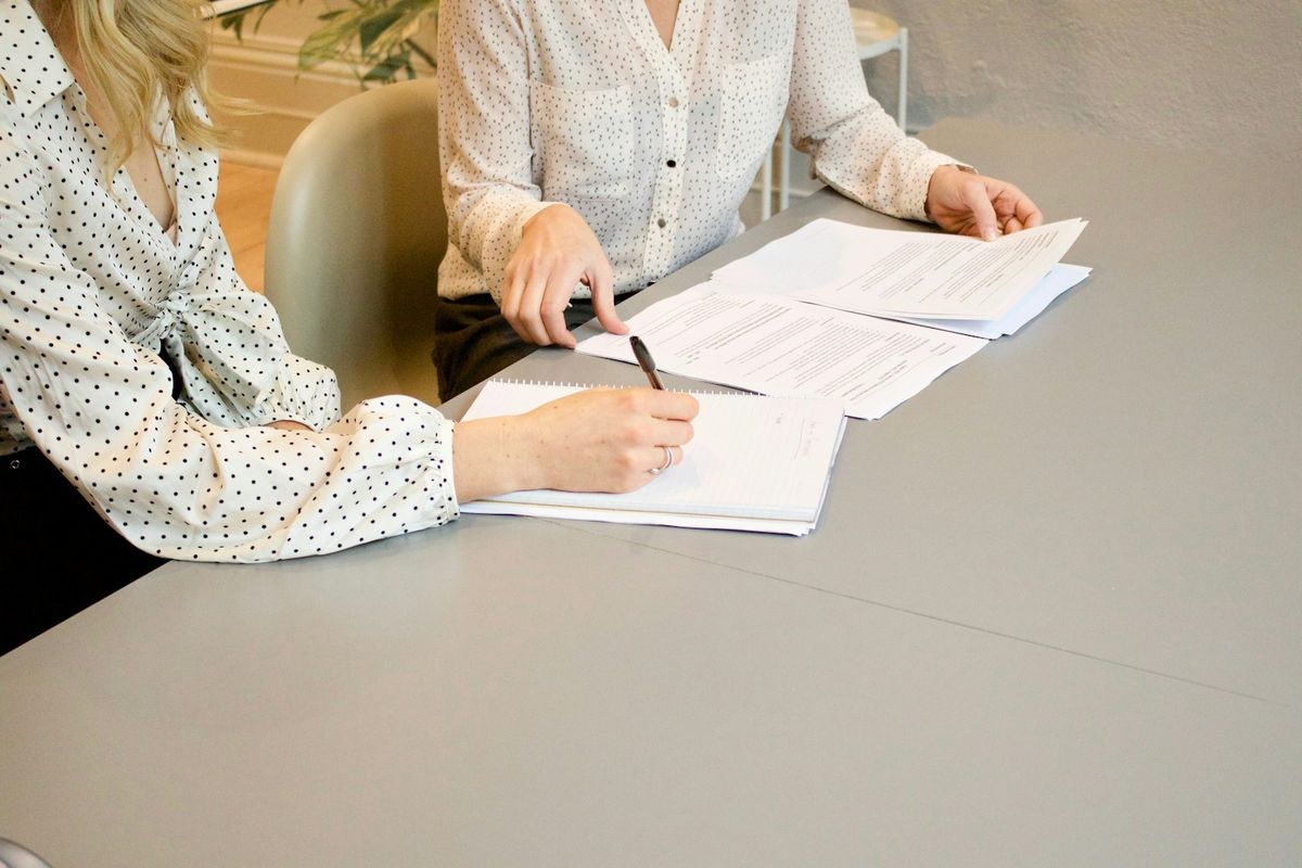 To personer signerer og gjennomgar faktura pa kontoret