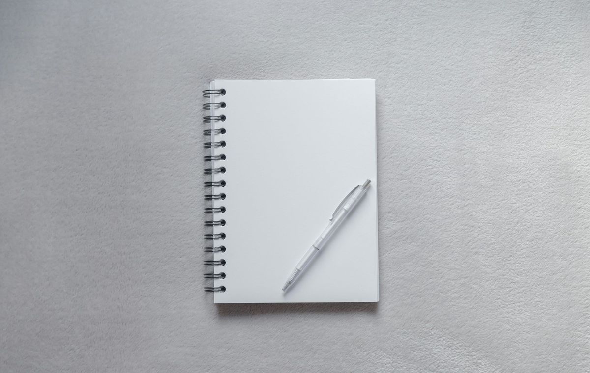 Blank notatbok med penn på skrivebord
