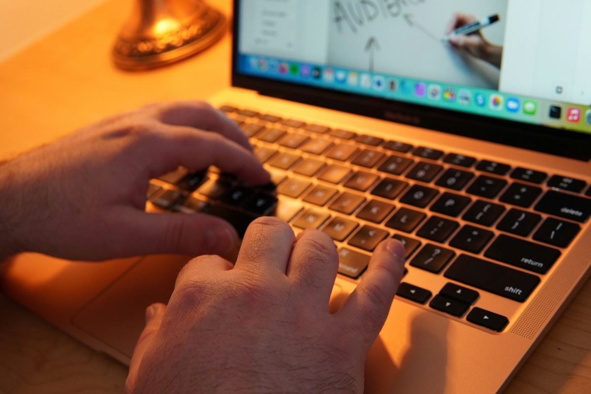 Hender skriver på et tastatur på laptop