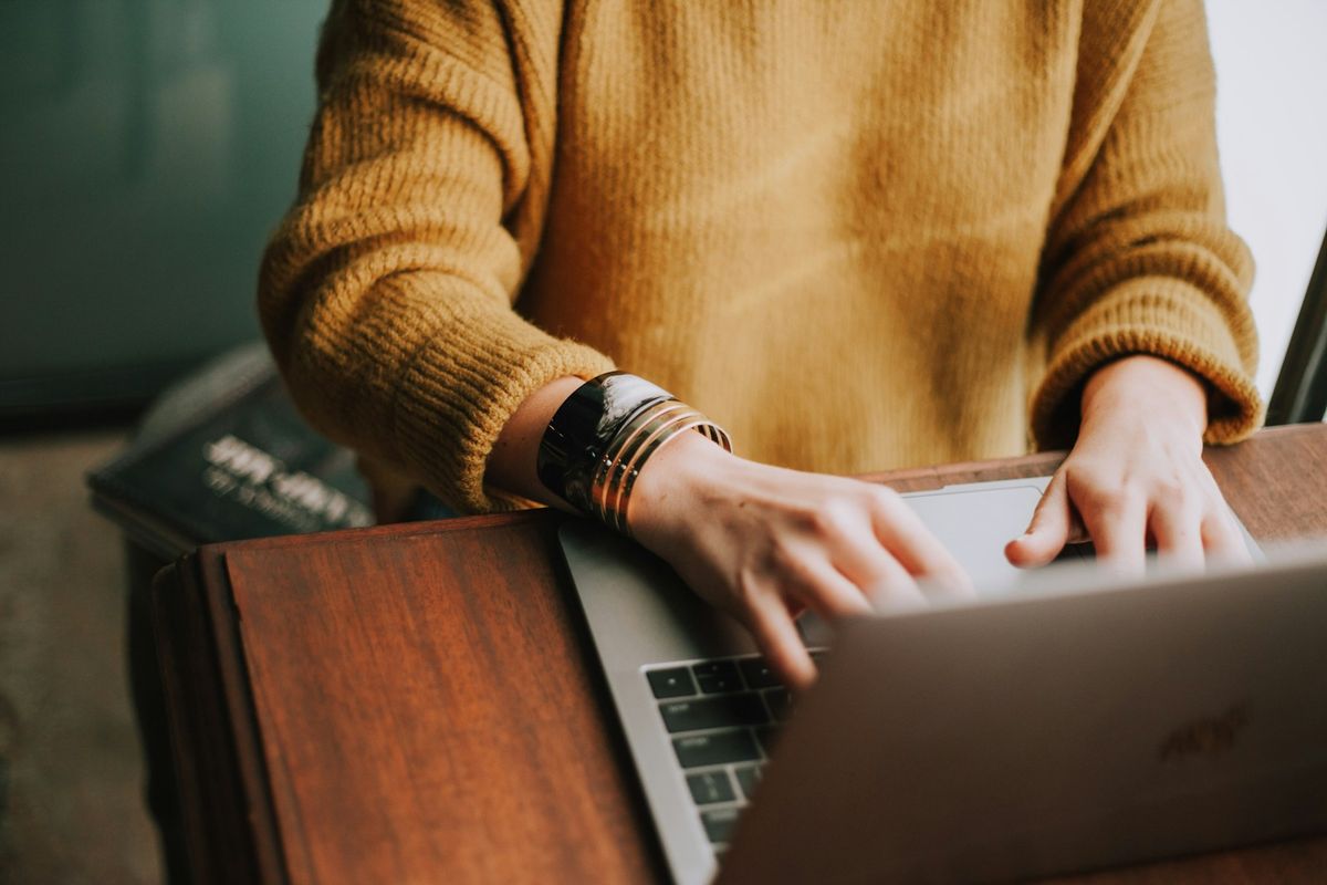 Person registrerer seg paa nett med laptop