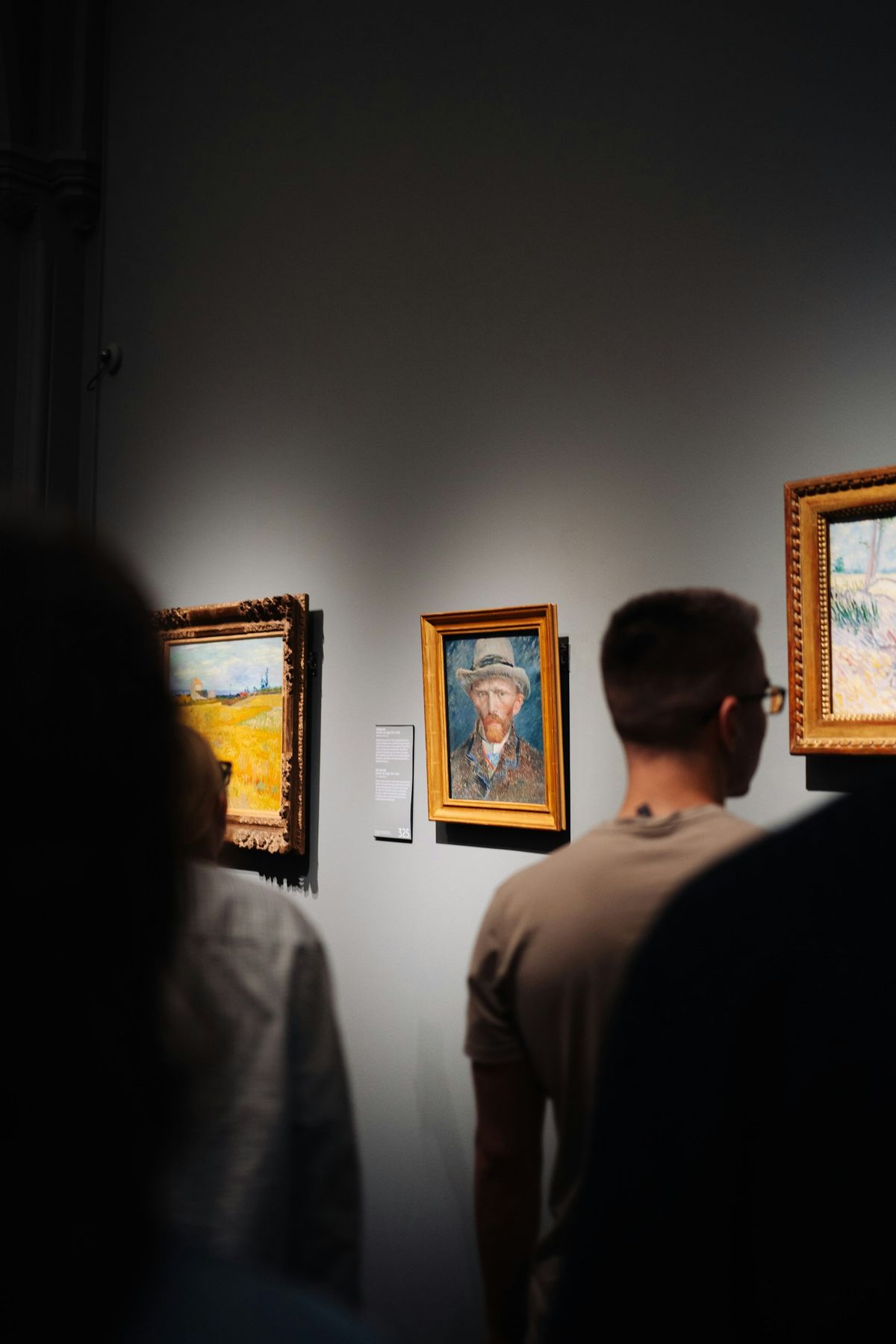Folk ser på malerier i et kunstgalleri