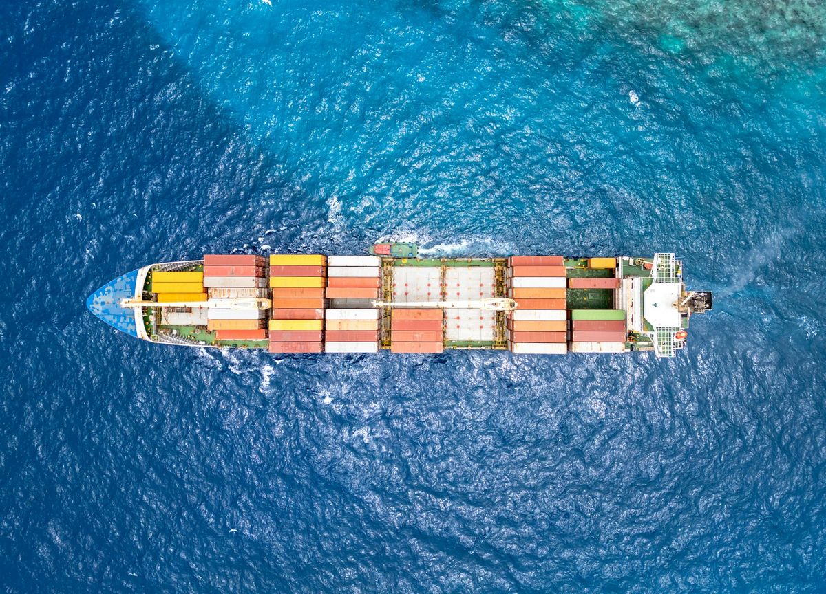 Flyfoto av containerskip pa havet med eksportlast