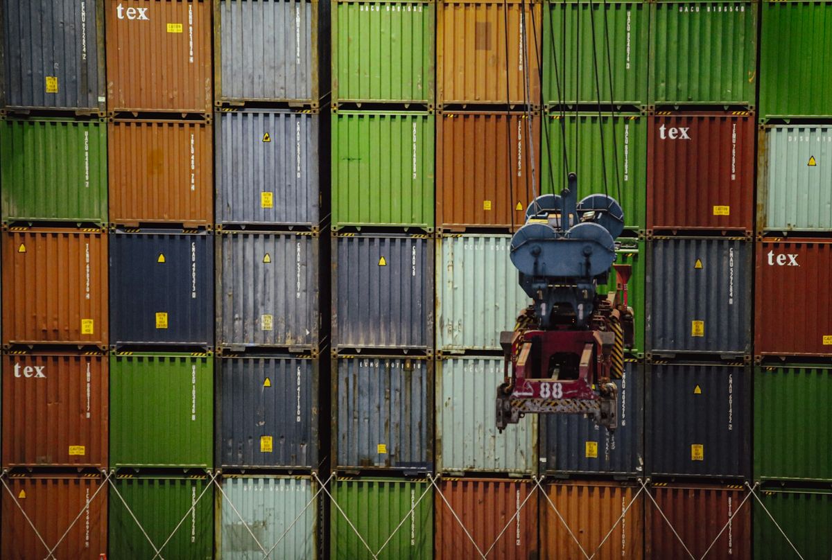 Stabler med fargerike fraktcontainere ved en terminal