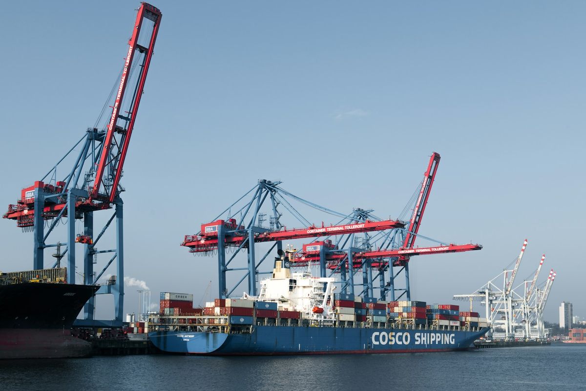 Stort lasteskip i havn med containerkraner