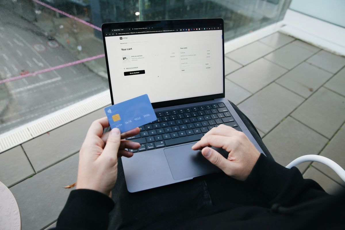 Person handler paa nett med laptop og bankkort